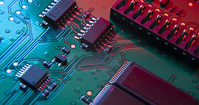 Nahaufnahme einer Leiterplatte (PCB) mit elektronischen Bauteilen und leitfähigen Verbindungen.